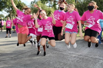 GOTR girls smiling and jumping at the 5K